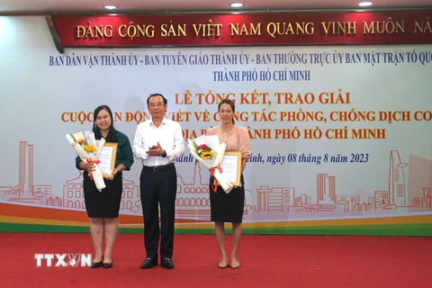 Ủy viên Bộ Chính trị, Bí thư Thành ủy Thành phố Hồ Chí Minh Nguyễn Văn Nên trao giải Nhất cá nhân cho 2 tác giả. (Ảnh: Thu Hoài/TTXVN)