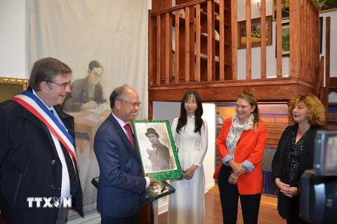 Đại sứ Đinh Toàn Thắng đón nhận bức ảnh lãnh tụ Nguyễn Ái Quốc-Chủ tịch Hồ Chí Minh do lãnh đạo thành phố Montreuil trao tặng. (Ảnh: Ngọc Hiệp/TTXVN)