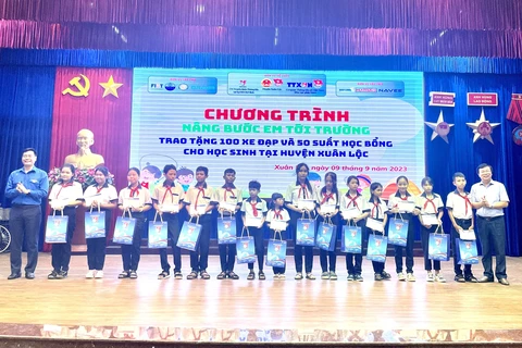 Đoàn Thanh niên TTXVN khu vực phía Nam trao 50 suất học bổng cho các em học sinh có hoàn cảnh khó khăn vươn lên trong học tập tại huyện Xuân Lộc, Đồng Nai. (Ảnh: Lê Xuân/TTXVN)