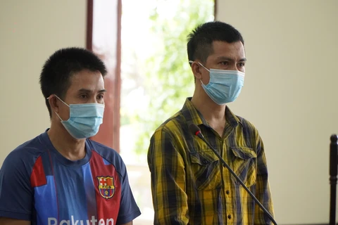 Hai bị cáo Ngô Hoàng Thọ (trái) và Phạm Hồng Qui tại phiên tòa. (Ảnh: Nhựt An/TTXVN) 