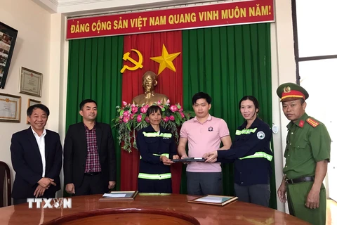 Chị Vũ Thị Thu và Khiếu Nữ Thị Thanh Chúc trao lại tài sản cho người bị mất. (Ảnh: TTXVN phát)