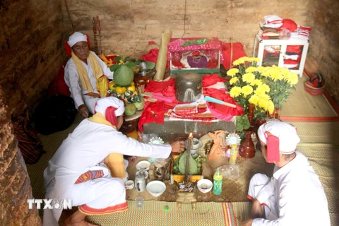Chức sắc tôn giáo người Chăm thực hiện các nghi lễ chính của lễ hội Katê mở cửa tháp, tắm bệ thờ Linga-Yoni. (Ảnh: Nguyễn Thanh/TTXVN)