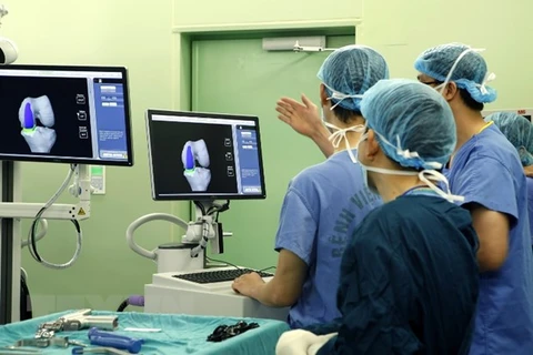 Cán bộ y tế hội chẩn kết quả chụp CT khớp gối của bệnh nhân tại Bệnh viện Bach Mai. (Ảnh: Dương Ngọc/TTXVN) 