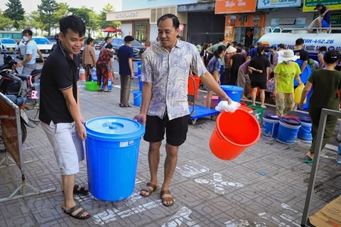 Người dân ở Khu Đô thị Thanh Hà lấy nước từ các xe bồn. (Ảnh: Hoài Nam/Vietnam+)