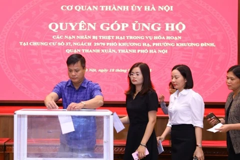 Cán bộ, công chức, viên chức và người lao động cơ quan Thành ủy Hà Nội quyên góp ủng hộ các nạn nhân trong vụ cháy chung cư mini tại quận Thanh Xuân. (Ảnh: Văn Điệp/TTXVN)