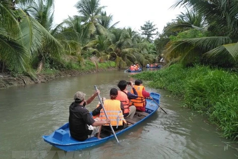 Du khách trải nghiệm hoạt động tự bơi xuồng trên sông trong Nông trại dê sữa du lịch Đông Nghi ở Tiền Giang. (Ảnh: Minh Hưng/TTXVN)