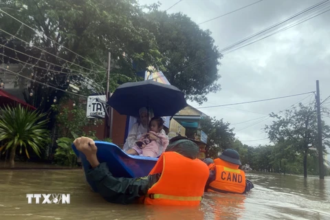 Lực lượng chức năng đưa người dân ở khu vực bị ngập sâu đến nơi an toàn. (Ảnh: TTXVN phát) 