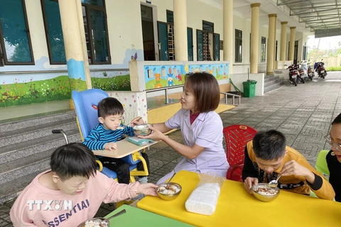 Các cô giáo tại Làng Trẻ em Mồ côi Hà Tĩnh chăm sóc trẻ trong giờ ăn trưa. (Ảnh: Hữu Quyết/TTXVN)