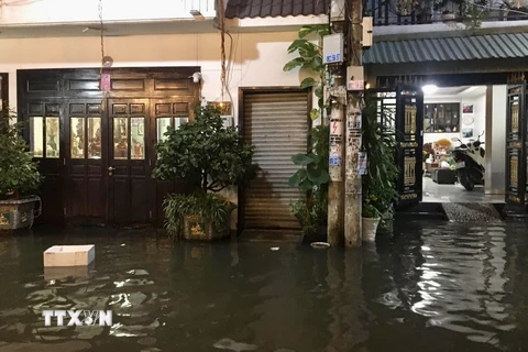 Triều cường gây nước ngập tràn vào nhà dân tại một tuyến hẻm trên đường Trần Xuân Soạn (Quận 7). ( Ảnh: Hồng Giang/TTXVN) 