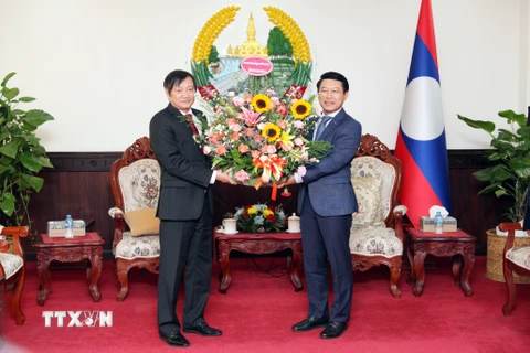 Đại sứ Nguyễn Bá Hùng tặng hoa chúc mừng 48 năm Quốc khánh nước Cộng hòa Dân chủ Nhân dân Lào. (Ảnh: Đỗ Bá Thành/TTXVN) 