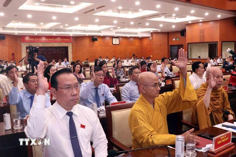 Đại biểu biểu quyết thông qua danh sách lấy phiếu tín nhiệm với những chức danh được Hội đồng Nhân dân Thành phố Hồ Chí Minh bầu. (Ảnh: Xuân Khu/TTXVN) 