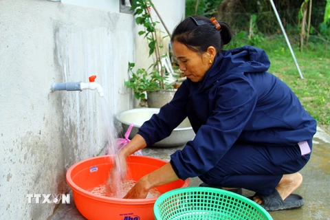 Người dân xã Mỹ Trạch (Bố Trạch, Quảng Bình) vui mừng khi được sử dụng nguồn nước sạch. (Ảnh: Tá Chuyên/TTXVN)