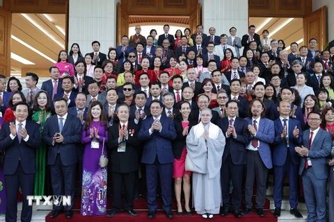 Thủ tướng Phạm Minh Chính chụp ảnh chung với kiều bào tiêu biểu dự Chương trình Xuân Quê hương 2023. (Ảnh: Dương Giang/TTXVN)