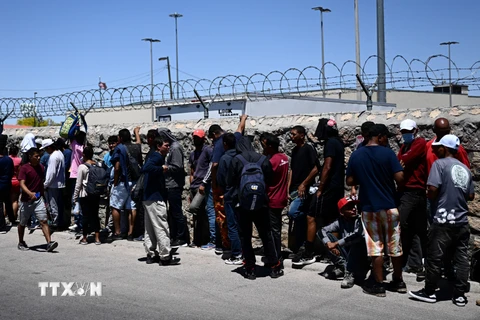 Người di cư chờ xét duyệt bên ngoài Cơ quan Kiểm soát Biên phòng Mỹ, sau khi vượt qua biên giới Mexico vào El Paso, bang Texas (Mỹ), ngày 9/5/2023. (Nguồn: AFP/TTXVN)
