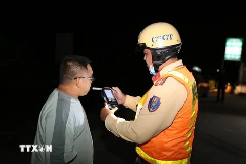 Cảnh sát Giao thông tỉnh Tiền Giang kiểm tra nồng độ cồn đối với tài xế xe ôtô. (Ảnh: Hữu Chí/ TTXVN)