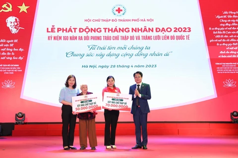Hội Chữ thập đỏ Thành phố Hà Nội, Hội Chữ thập Đỏ quận Cầu Giấy trao kinh phí hỗ trợ xây 02 nhà Chữ thập Đỏ tại buổi lễ phát động Tháng Nhân đạo năm 2023. (Ảnh: Thanh Tùng/TTXVN)