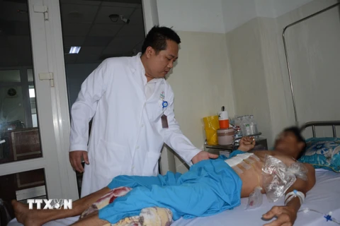 Bác sỹ Chuyên khoa II Nguyễn Văn Hải Vân khám cho bệnh nhân sau phẫu thuật. (Ảnh: Văn Dũng/TTXVN)