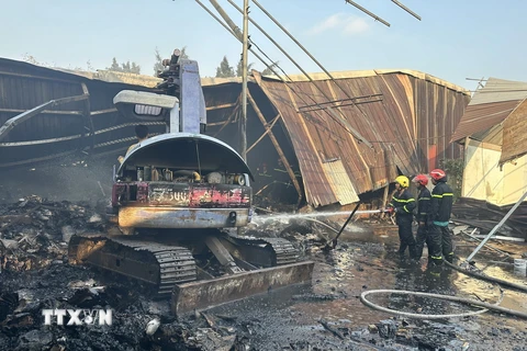 Lực lượng cảnh sát phòng cháy chữa cháy nỗ lực dập tắt đám cháy tại Công ty trách nhiệm hữu hạn sản xuất bao bì Hợp Nhất. (Ảnh: TTXVN phát)