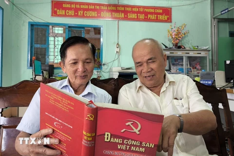 Ông Lê Văn Thiệm (bên trái) tại ấp 6, thị trấn Giồng Trôm (Bến Tre), Đảng viên 35 năm tuổi đảng trao đổi nghiên cứu văn kiện của Đảng với đảng viên trong chi bộ. (Ảnh: Huỳnh Phúc Hậu/TTXVN)