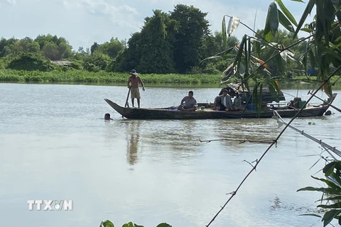 Lực lượng chức năng địa phương cùng người dân đang nỗ lực tìm kiếm 3 bé gái mất tích nghi đuối nước trên sông Sài Gòn đoạn qua tỉnh Bình Dương. (Ảnh: TTXVN phát)