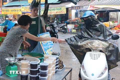 Người dân mua rượu nếp tại chợ Hàng Bè sáng Tết Đoan Ngọ. (Ảnh: Hoàng Hiếu/ TTXVN)