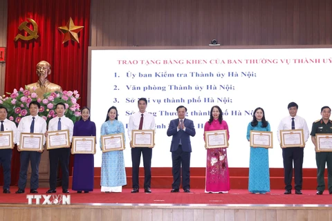 Bí thư Thành ủy Hà Nội Đinh Tiến Dũng trao tặng Bằng khen của Ban Thường vụ Thành uỷ cho các đơn vị có thành tích xuất sắc. (Ảnh: Doãn Tấn/TTXVN)