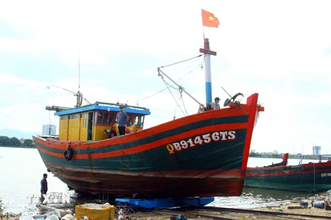 Ngư dân tỉnh Quảng Bình đưa tàu lên bờ để thực hiện kiểm tra để hoàn thành hồ sơ thủ tục cấp phép. (Ảnh: Tá Chuyên/TTXVN)