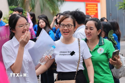 Niềm vui của phụ huynh và thí sinh tại điểm thi Trường Trung học Cơ sở Ngô Sĩ Liên, quận Hoàn Kiếm sau khi hoàn thành bài thi Ngữ văn. (Ảnh: Hoàng Hiếu/TTXVN)