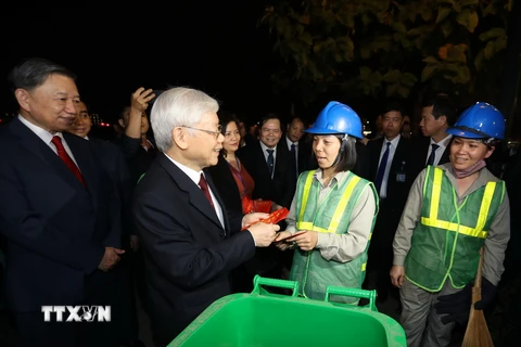 Tổng Bí thư, Chủ tịch nước Nguyễn Phú Trọng chúc Tết, tặng quà công nhân môi trường đang làm việc trong đêm giao thừa Tết Nguyên đán Kỷ Hợi 2019. (Ảnh: Trí Dũng/TTXVN)