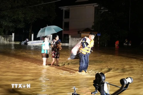 Lực lượng công an thành phố Yên Bái giúp người dân phường Hồng Hà di chuyển ra khỏi khu vực ngập úng trong đêm ngày 8/9. (Ảnh: TTXVN phát)