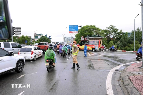 Lực lượng chức năng tổ chức phân luồng giao thông tại đầu cầu Chương Dương (phía quận Long Biên). (Ảnh: Vũ Sinh/TTXVN)