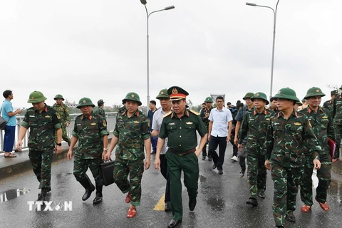 Trung tướng Phạm Đức Duyên, Bí thư Đảng ủy, Chính ủy Quân khu 2 và đại diện các đơn vị khảo sát vị trí lắp cầu phao. (Ảnh: TTXVN phát)