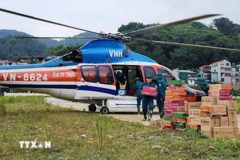 Chuyển hàng cứu trợ từ trực thăng xuống vùng lũ thuộc huyện Nguyên Bình. (Ảnh: Thông tấn Quân sự/TTXVN phát)