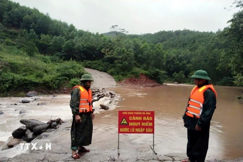 Lực lượng Đồn Biên phòng Ra Mai (Bộ đội Biên phòng tỉnh Quảng Bình) chốt chặn không cho người dân qua các ngầm tràn khi nước lũ dâng cao. (Ảnh: TTXVN phát)