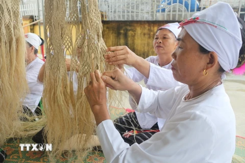 Phụ nữ dân tộc Thổ đan võng gai. (Ảnh: Bích Huệ/TTXVN)