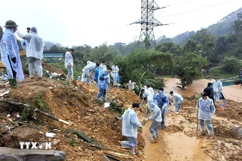 Cán bộ, chiến sỹ Công an tỉnh Hà Giang và các lực lượng chức năng nỗ lực tìm kiếm nạn nhân mất tích trong vụ sạt lở nghiêm trọng. (Ảnh: TTXVN phát)