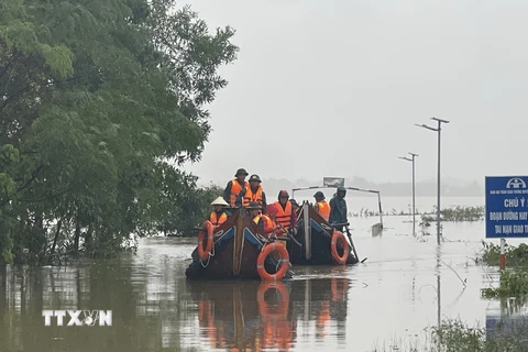 Các lực lượng chức năng di chuyển bằng thuyền hỗ trợ người dân vùng ngập lụt ở Quảng Trị. (Ảnh: Thanh Thủy/TTXVN)