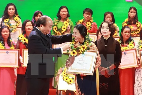 Thủ tướng Nguyễn Xuân Phúc tặng hoa cho các phụ nữ điển hình tiên tiến. (Ảnh: TTXVN)