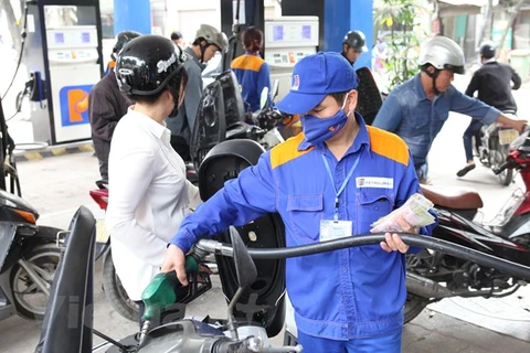 Nhân viên Petrolimex đang bán xăng cho khách hàng. (Ảnh: Đức Duy/Vietnam+)