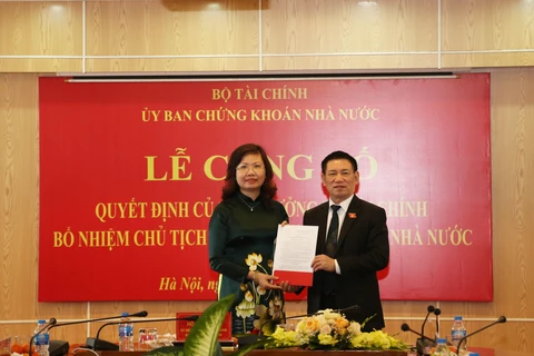 Bộ trưởng Bộ Tài chính Hồ Đức Phớc trao quyết định bổ nhiệm Chủ tịch Ủy ban Chứng khoán Nhà nước đối với bà Vũ Thị Chân Phương. (Ảnh: Vietnam+)