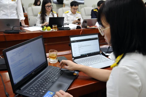Các công chức ngành thuế đang hỗ trợ trực tuyến quyết toán thuế năm 2022. (Ảnh: CTV/Vietnam+)