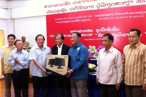 Thứ trưởng Trương Minh Tuấn tặng máy tính cho Bộ Thông tin Văn hóa và Du lịch Lào. (Ảnh: CTV/Vietnam+)