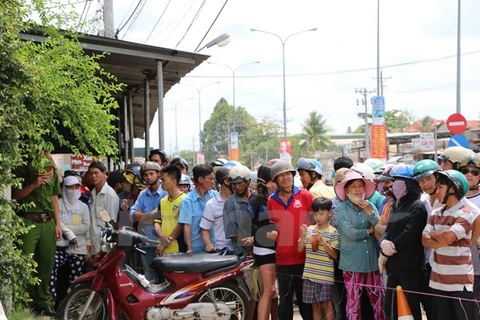 Người dân hiếu kỳ đến xem trước nhà nạn nhân. (Nguồn: Nguyễn Văn Việt/Vietnam+)