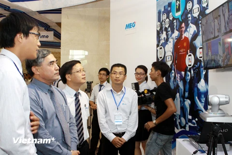 Thứ trưởng Bộ TT-TT Nguyễn Minh Hồng (thứ 2 từ trái sang) nghe giới thiệu về VNPT VinaPhone. (Ảnh: Minh Quyết/Vietnam+)