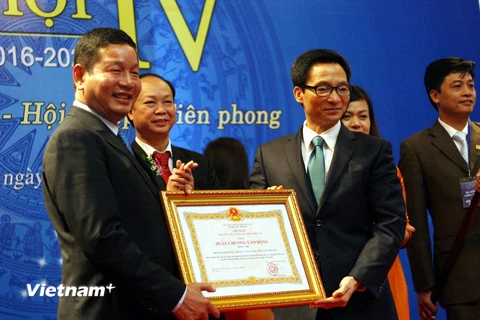Ông Trương Gia Bình (trái) thay mặt VINASA nhận Huân chương Độc lập hạng Nhì. (Ảnh: Trung Hiền/Vietnam+)
