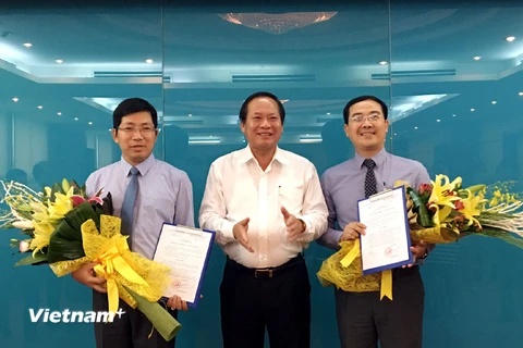 Bộ trưởng Trương Minh Tuấn trao quyết định cho ông Lưu Đình Phúc (trái) và ông Đinh Tiến Dũng (phải). (Ảnh: CTV/Vietnam+)
