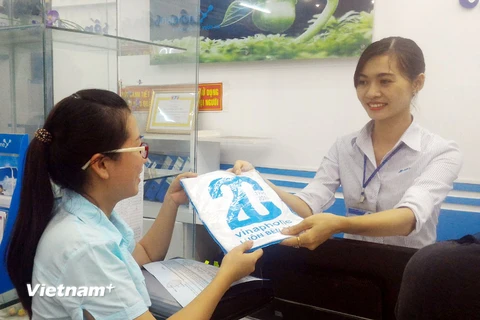 Tặng quà cho khách hàng nhân dịp kỷ niệm 20 năm VinaPhone (26/6/1996-26/6/2016) tại điểm giao dịch ở Đồng Hới, Quảng Bình. (Ảnh: T.H/Vietnam+)