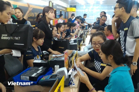 Nhiều khách hàng đã "tạm quên" cơn bão số 3 để đến trải nghiệm và mua Galaxy Note 7. (Ảnh: T.H/Vietnam+)