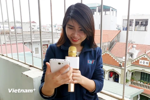 Bạn La Thị Khách (sinh viên Học viện Hành chính Hà Nội) rất thích chiếc Micro Karaoke YS 11 và cho biết sản phẩm này sẽ sẽ làm cho những ngày Tết trở nên vui vẻ hơn. (Ảnh: Lương Hòa/Vietnam+)