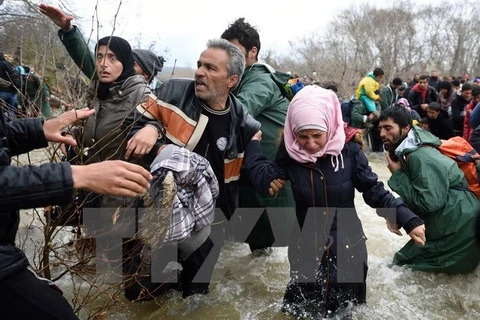 Người di cư và tị nạn cố gắng vượt sông qua khu vực biên giới Hy Lạp-Macedonia để tới Macedonia ngày 14/3/2016. (Ảnh minh họa. Nguồn: AFP/TTXVN)